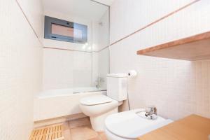 a white bathroom with a toilet and a sink at Stay Barcelona Vila de Gracia in Barcelona
