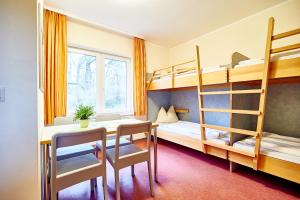 a room with a desk and bunk beds at Jugendherberge Jever in Jever +13 photos
