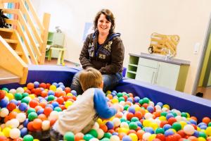 a woman and a child playing in a pile of balls at Jugendherberge Jever in Jever