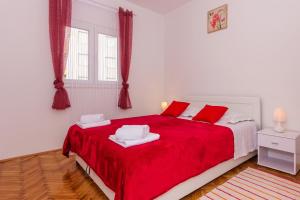 a bedroom with a large red bed with red pillows at Apartment Ema in Split