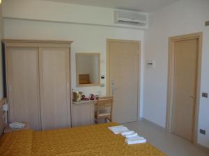 een slaapkamer met een bed en een tafel met een bureau bij Hotel Capitano in Tortoreto Lido