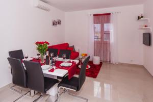 a dining room table with black chairs and a red couch at Apartment Ema in Split