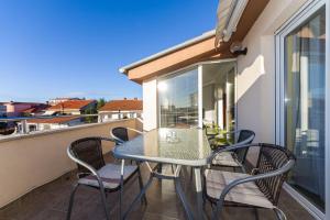 balcón con mesa y sillas en Apartments Villa Rotim, en Zadar