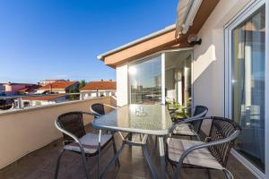 a balcony with a table and chairs on a balcony at Apartments Villa Rotim in Zadar