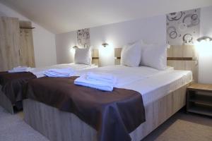 Habitación de hotel con 2 camas y toallas. en Pensiunea Argesu **, en Sinaia