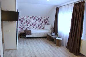 a bedroom with a bed and a large window at Pensiunea Argesu ** in Sinaia