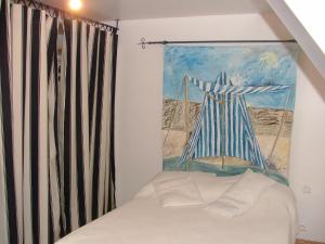 Habitación con cama y pintura en la pared en Gîtes du Vieux Presbytère, en Baguer-Pican