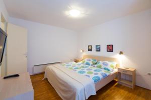 a small bedroom with a bed and a television at Aloe in Mali Lošinj