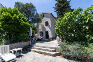 una casa con alcune sedie, alberi e scale di Aloe a Mali Lošinj (Lussinpiccolo)