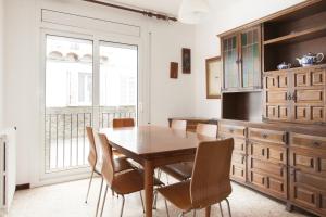 a dining room with a wooden table and chairs at Akira Flats Cadaqués Apartments in Cadaqués
