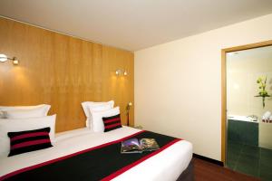 a hotel room with a large bed and a shower at Residhome Suites Paris Sénart in Lieusaint