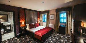 a hotel room with a bed and a television at The Torrance Hotel in East Kilbride