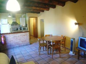 a kitchen and dining room with a table and chairs at Casa Mur Artesania in Lecina