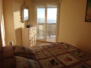 a bedroom with a bed and a window with a balcony at Torremar I in Torredembarra