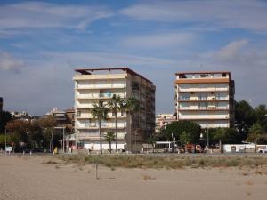 dos edificios altos junto a una playa con palmeras en Torremar I en Torredembarra