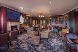 a hotel lobby with a fireplace and tables and chairs at The Glencarn Hotel in Castleblayney