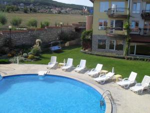 a swimming pool with lounge chairs and a house at Black Sea Royal Villa in Rogachevo