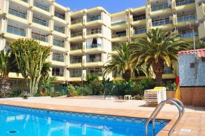 un hotel con piscina frente a un edificio en Apartamentos Roque Nublo, en Playa del Inglés