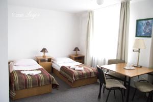 a hotel room with two beds and a table at Hotel Logos in Lublin