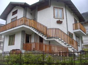 una casa con balcones de madera y escaleras. en Residenza La Ruina, en Fenestrelle