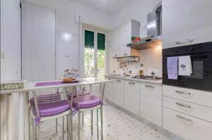 ローマにあるNinuphar Maisonのキッチン(白いキャビネット、紫色のバースツール付)