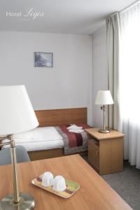 una camera d'albergo con letto e tavolo con lampada di Hotel Logos a Lublino