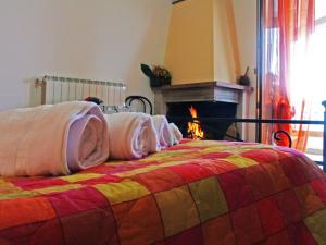 チッタ・サンタンジェロにあるVilla Leandraのベッド(上に枕付)、暖炉が備わります。