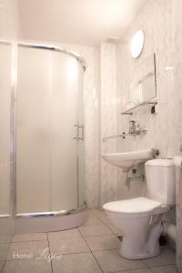 La salle de bains est pourvue d'une douche, de toilettes et d'un lavabo. dans l'établissement Hotel Logos, à Lublin