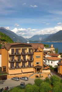 a large hotel with cars parked in a parking lot at Hotel 2000 in Gravedona