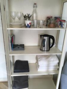 a white shelf with a tea kettle and dishes at B&B Huize 't Goylaan in Utrecht