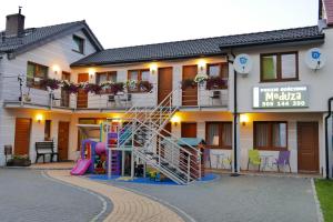 un hotel con parque infantil frente a un edificio en Pokoje Meduza Łeba, en Łeba
