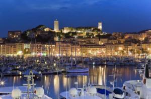 ein Hafen mit Booten in einer Stadt in der Nacht in der Unterkunft Teisseire Accomodations in Cannes