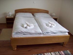 a bed with white sheets and three towels on it at House Mara in Korenica