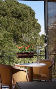 una mesa con un jarrón de flores en el balcón en Hotel Giardino Inglese en Palermo