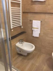 a bathroom with a toilet and a sink and towels at Nonna's Affittacamere in Sanremo +24 photos