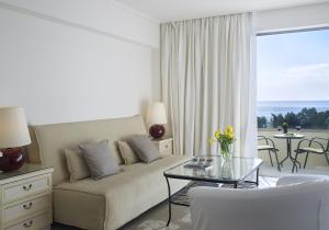 a living room with a couch and a glass table at Amarilia Hotel in Athens