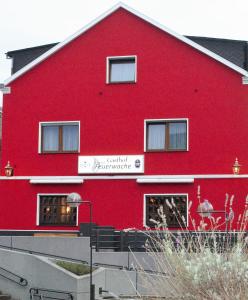 un edificio rojo con un cartel en el costado en Gasthof zur alten Feuerwache, en Bad Hönningen