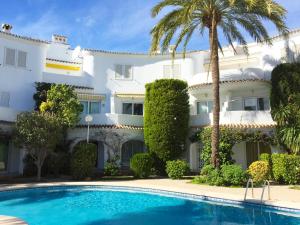 een groot wit gebouw met een zwembad en palmbomen bij Anacasa Oasis Beach II Marineta AP2116 in Denia