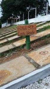 烏巴雅拉的住宿－Pousada Sitio Costa Verde，坐在长凳上的一个木标志
