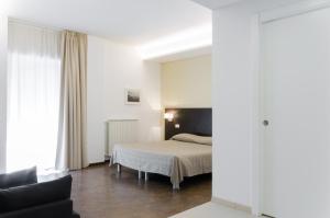 1 dormitorio con 1 cama y 1 sofá en Le Stanze Sul Corso en Pescara