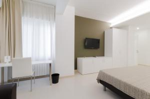 1 dormitorio con 1 cama y TV en la pared en Le Stanze Sul Corso, en Pescara