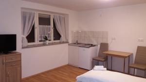 a bedroom with a bed and a kitchen with a sink at Gästehaus B & B27 und Pension Waldhorn in Rottweil