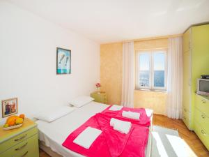 ein Schlafzimmer mit einem großen Bett mit einer roten Decke in der Unterkunft Apartments Adria in Petrovac na Moru