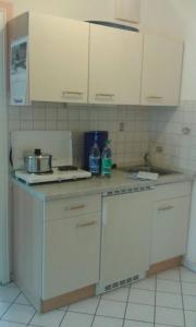 a kitchen with white cabinets and a counter top at 2 Zimmer Kursuite Bad Füssing in Bad Füssing