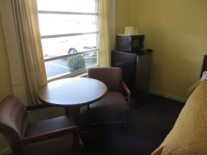 ヘインズ・シティにあるState Motel Haines Cityのテーブルと窓が備わる小さな客室です。