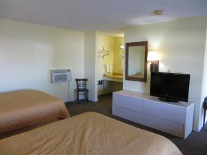 a hotel room with a bed and a flat screen tv at State Motel Haines City in Haines City