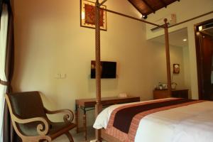 a bedroom with a bed and a chair in a room at Adys Inn in Legian