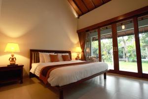 a bedroom with a bed and a large window at Adys Inn in Legian