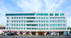 SÀI GÒN - BẠC LIÊU Hotel في Bạc Liêu: مبنى ابيض كبير عليه ديكورات العيد