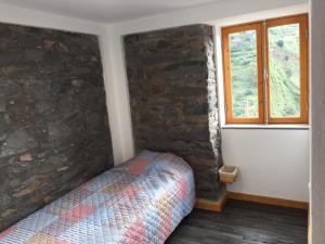 Madalena do MarにあるQuinta Ribeiraの石壁のベッドルーム1室(ベッド1台付)